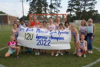 2022 12U House League Champion team with their winning banner.